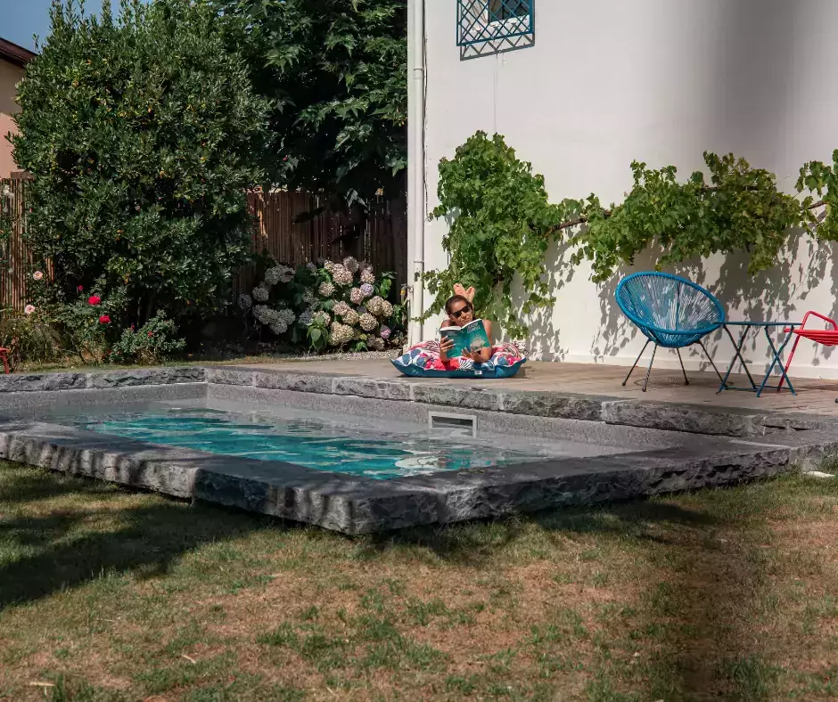 piscine avec des margelles épaisses en pierre en grès d'inde