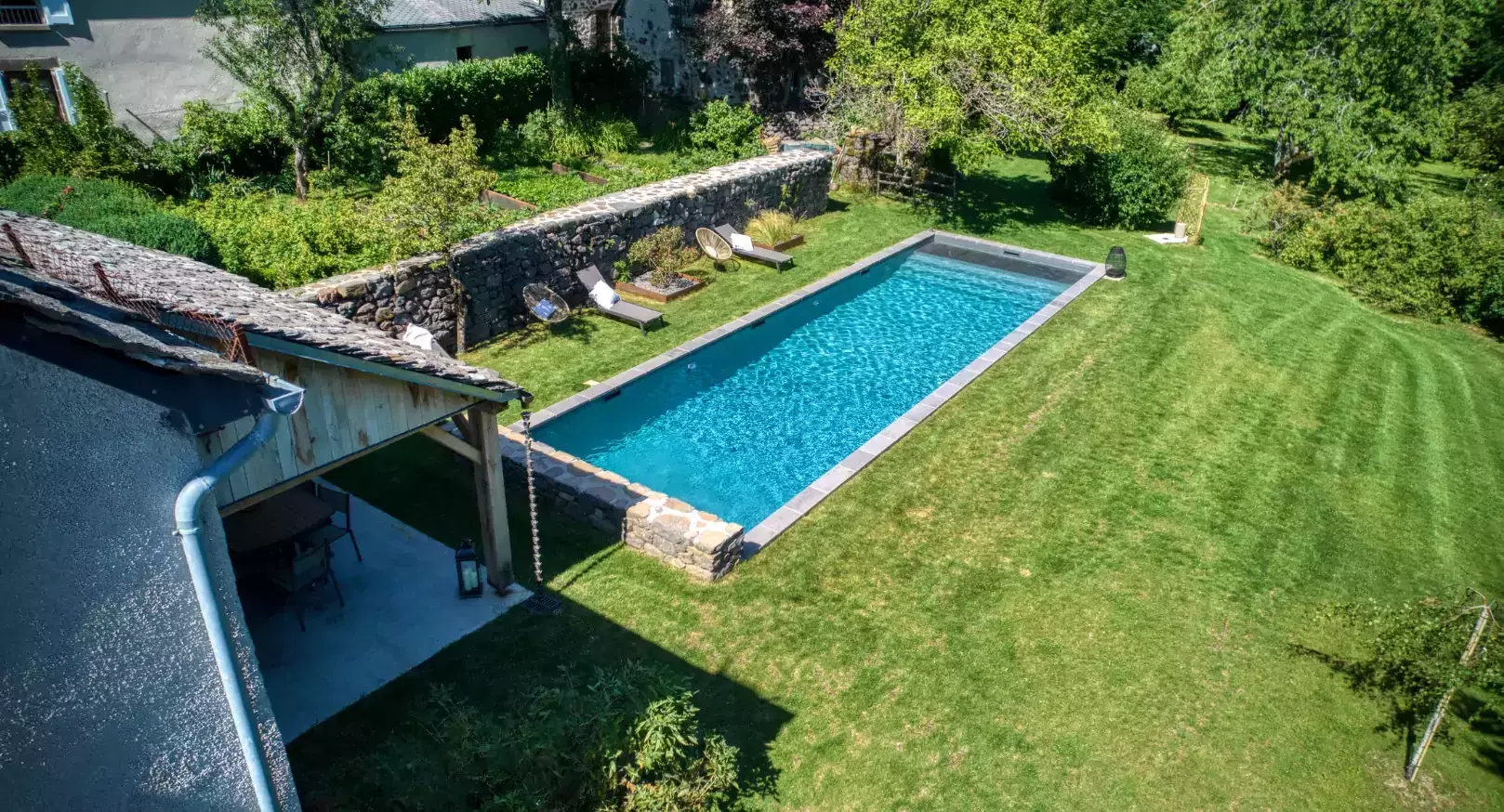 réation d'une piscine allongée dans le jardin d'une demeure au cœur d'un village français renommé pour sa beauté