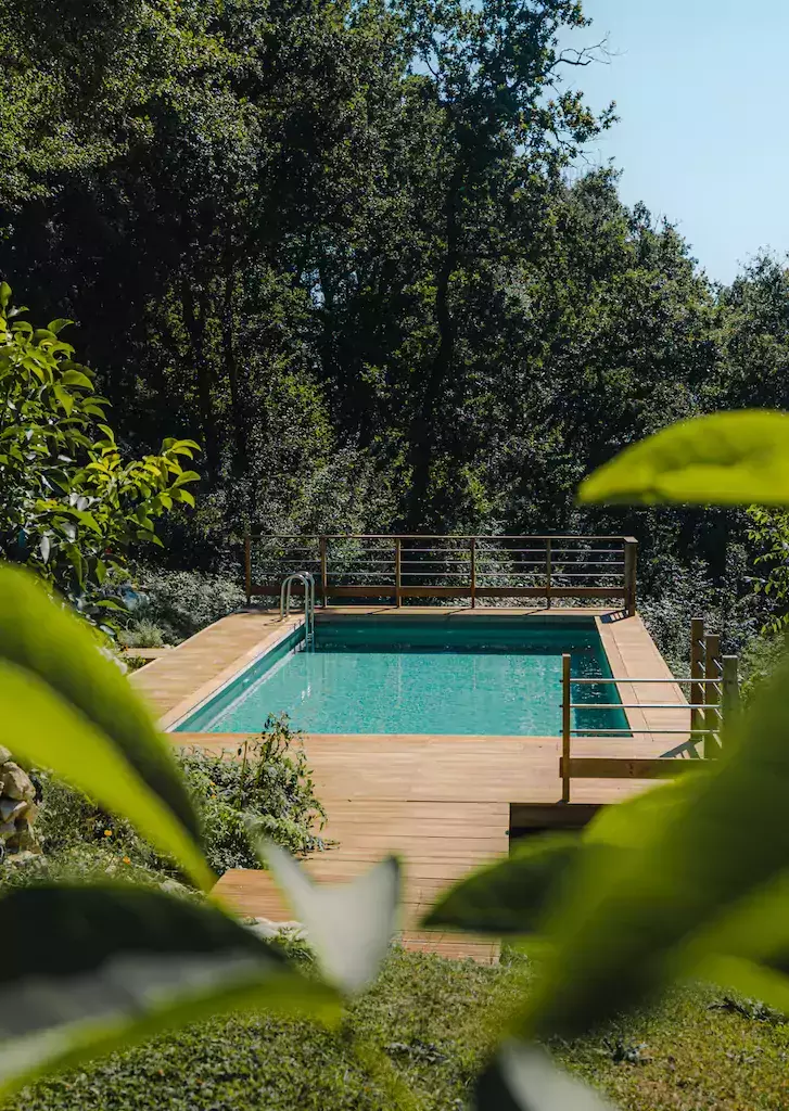 piscine avec terrasse en bois suspendue au dessus d'un champs de tournesol